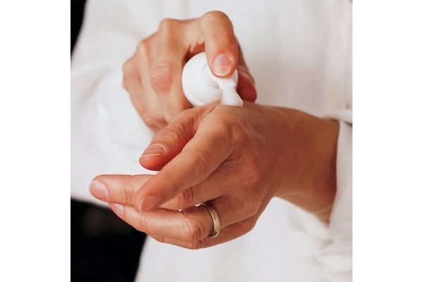 Image Pumping a foam skincare onto the backside of a hand.